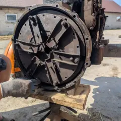 Regulacja sprzęgła w C330. Mechanik w rękawiczkach dokręca śruby w tarczy sprzęgła Ursusa C330.