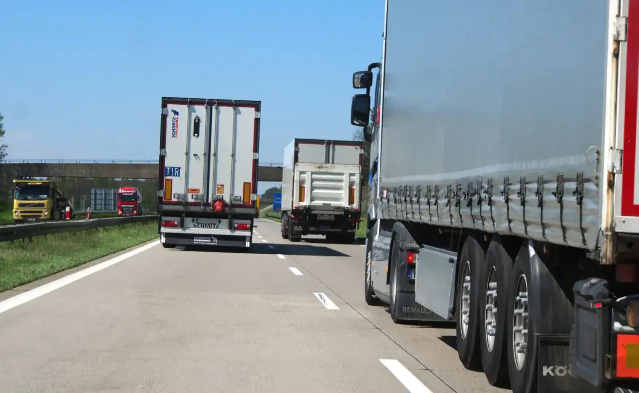 Ciężarówki jadące autostradą. Od kiedy zakaz wyprzedzania dla ciężarówek, ruch jest płynny, ale wolniejszy.