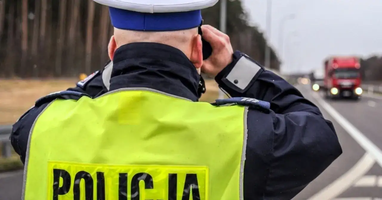 Policjant w kamizelce odblaskowej obserwuje ruch. Od kiedy zakaz wyprzedzania dla ciężarówek, kontrola na drodze jest kluczowa.